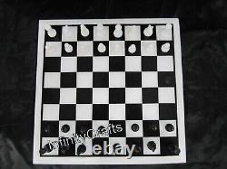 Table de café en marbre blanc avec incrustations de design d'échecs sur le dessus pour jouer aux échecs.